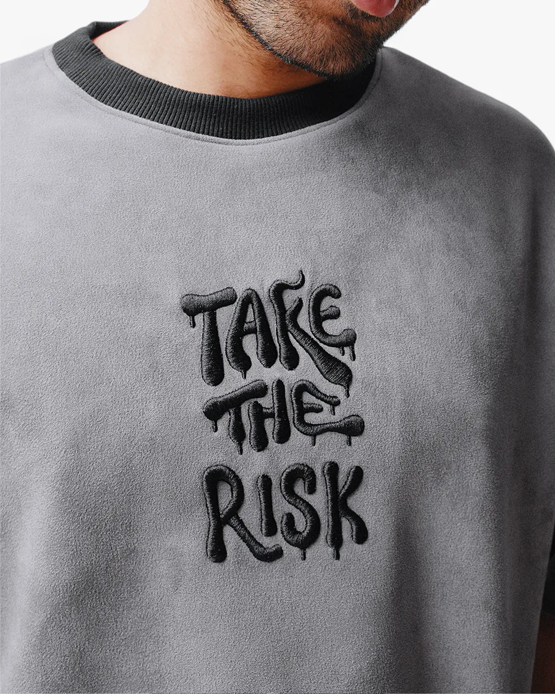 Close-up view of chest detail on Take The Risk Grey vegan fur cropped oversized t-shirt