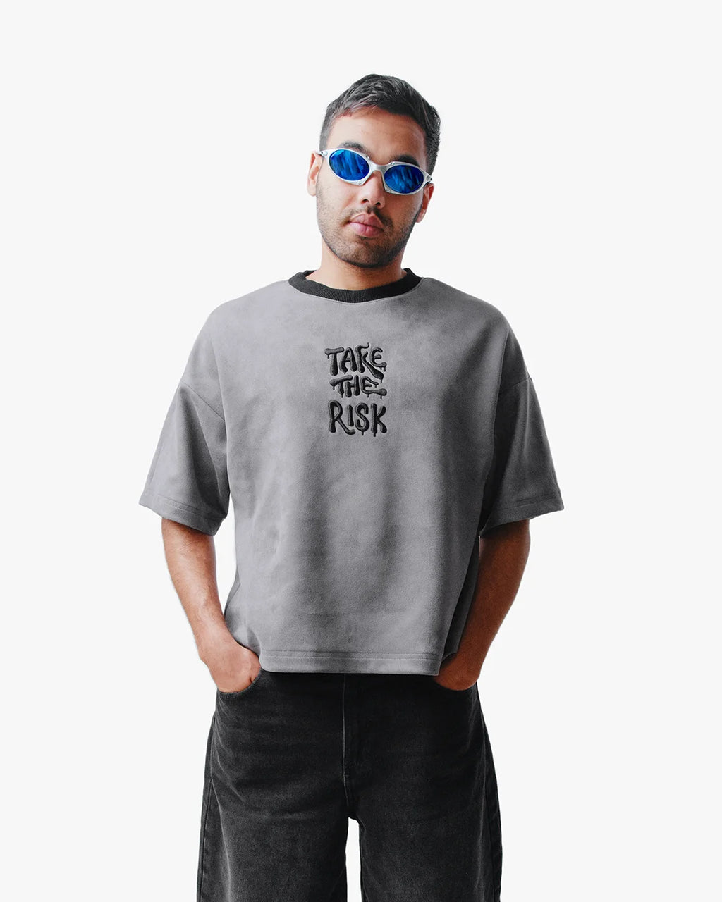 Man wearing Take The Risk Grey vegan fur cropped oversized t-shirt with blue rimless sunglasses