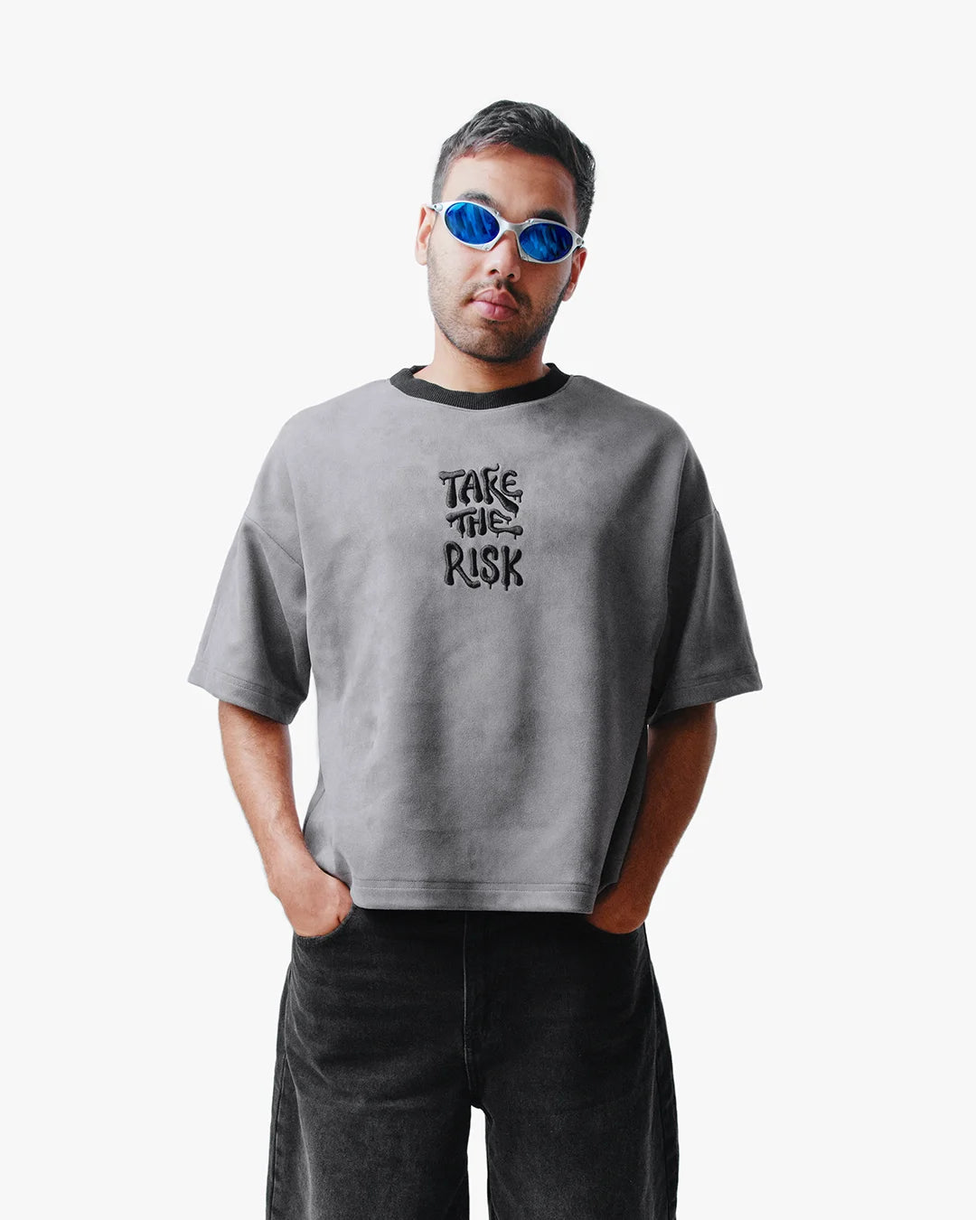 Man wearing Take The Risk Grey vegan fur cropped oversized t-shirt with blue rimless sunglasses