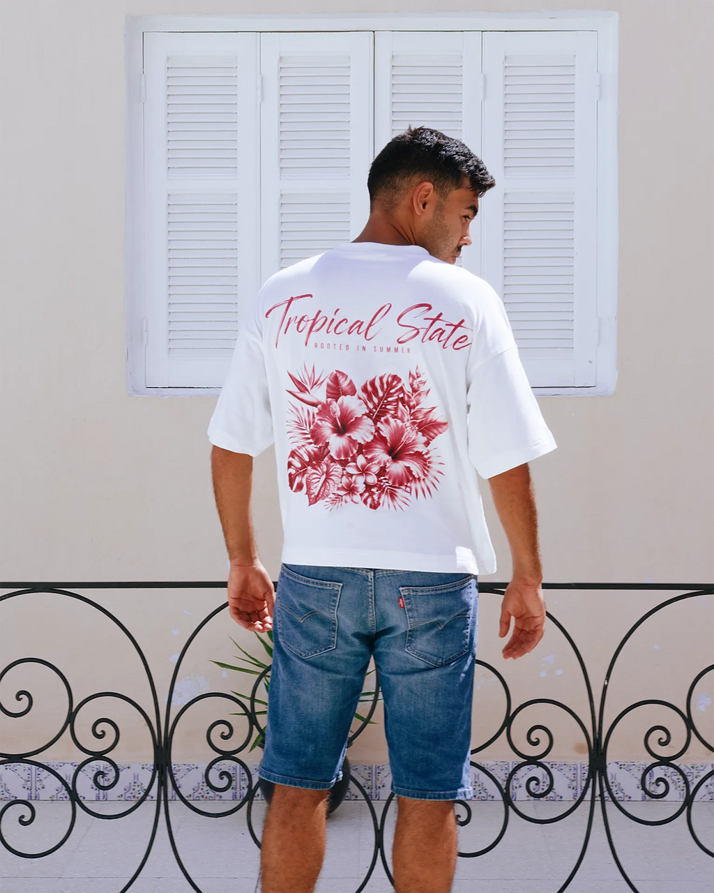 Close-up of tropical hibiscus and monstera graphic print on TROPICAL STATE™ cropped oversized T-shirt in White