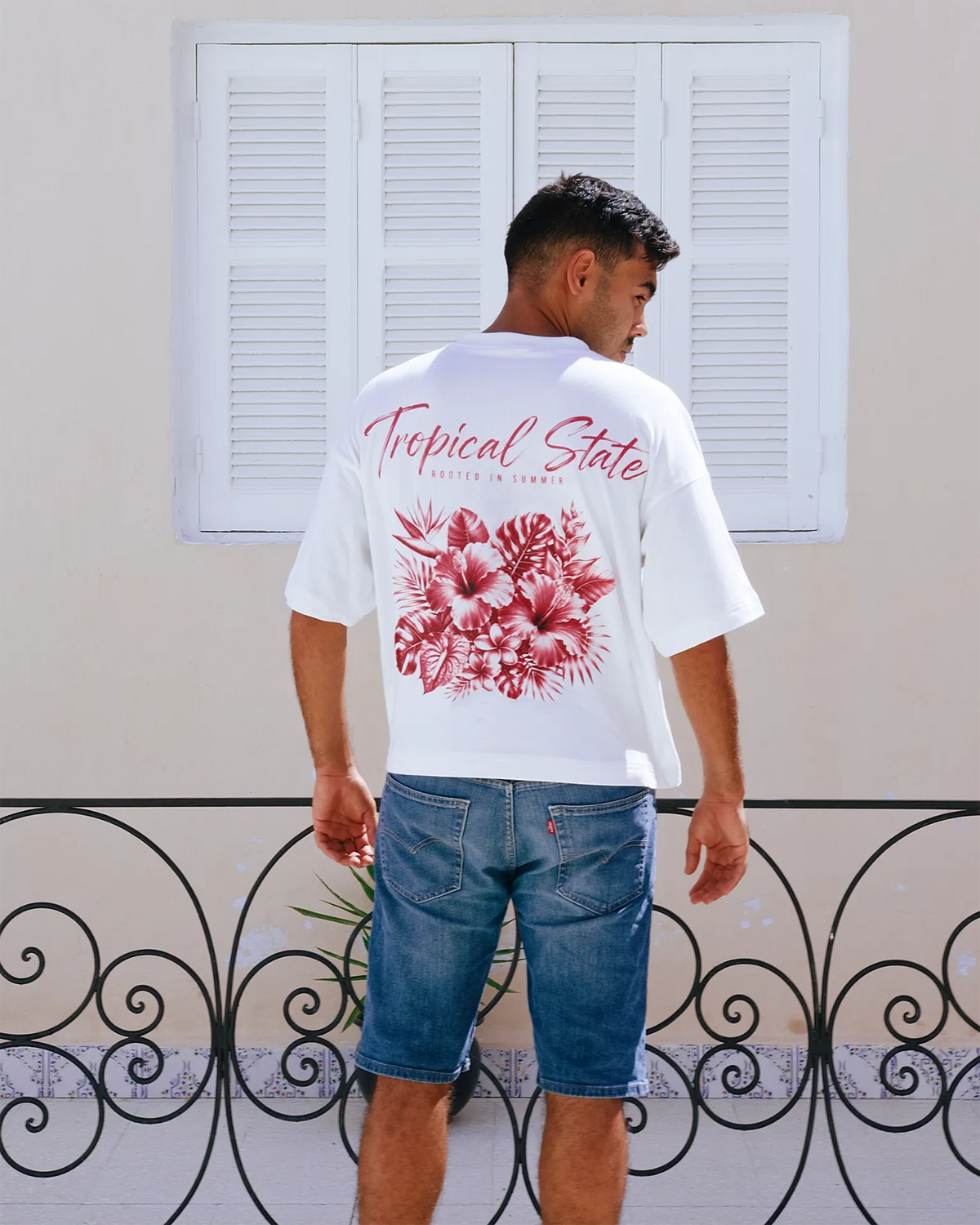 Close-up of tropical hibiscus and monstera graphic print on TROPICAL STATE™ cropped oversized T-shirt in White